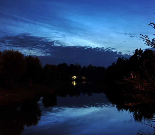 De prachtige lichtende nachtwolken van 14 juli 2009. De donkere vlekken op de voorgrond zijn lokale wolken en vandaar donker (foto Peter van Bommel).