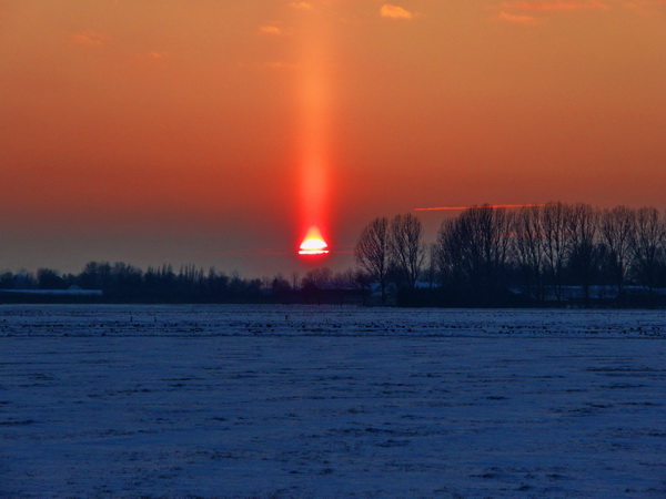 Een mooie lichtzuil is zichtbaar boven de ondergaande zon in Oostwoud (foto genomen door Frank Pereboom op 3 februari ±17:20).